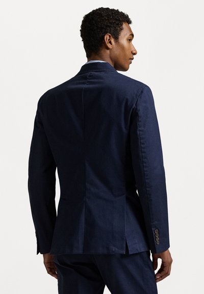 Sötétkék blézer sima anyagból, testre szabott kialakítással, hátul egy középső szellőzővel és négy gombos mandzsettadíszítéssel.