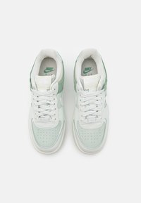 Nike Air-sneakers med en ljus mintgrön ovandel, vita accenter, perforerat tåfack och en texturerad panel på kragen. Klassisk snörning.