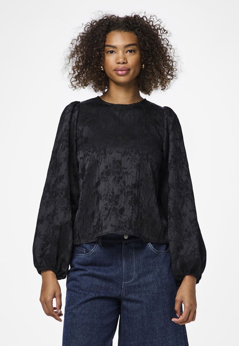 Blusa nera a fiori con maniche a sbuffo e scollatura rotonda. Realizzata in tessuto testurizzato, presenta motivi sottili e una vestibilità morbida.