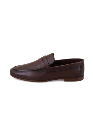 Zapato tipo mocasín penny de cuero marrón oscuro con tacón bajo y puntera redondeada, mostrado desde el lado exterior sobre un fondo blanco.