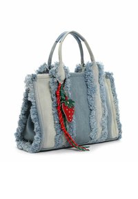Torba z denimu z postrzępionymi krawędziami, panelami w jasnym i ciemnym odcieniu niebieskiego, podwójnymi uchwytami oraz czerwonym breloczkiem w kształcie truskawki z zielonymi akcentami.