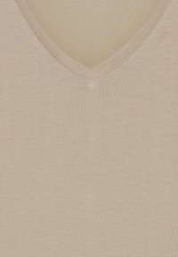 Beige v-neck top vyrobený z měkké, elastické tkaniny. Má hladký povrch a precizní švy podél výstřihu, bez viditelných vzorů.