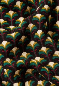 Tessuto con sfondo nero e un motivo floreale ripetuto. I colori includono crema, oro, verde e rosso, con una superficie texture.
