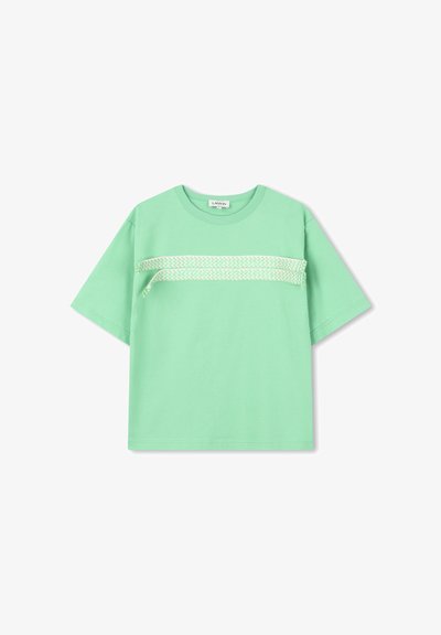 T-shirt en coton vert menthe à manches courtes, avec un motif en zigzag blanc sur la poitrine. Encolure ronde simple, coupe décontractée.