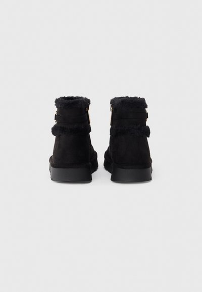 Svarta mocka ankboots med en mjuk pälsbesättning vid kragen, med två dekorativa remmar och en platt gummisula.