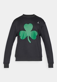 Sweat-shirt noir à manches longues avec un grand motif de trèfle vert à trois feuilles et un petit logo Jumpman blanc sur la partie supérieure droite de la poitrine.