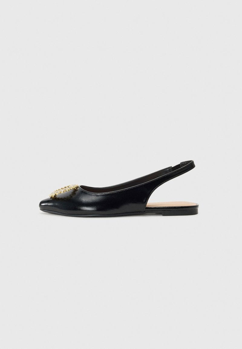 Chaussure plate slingback en cuir verni noir avec bout pointu et ornement décoratif doré à l’avant.