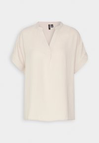 Löst sittande krämfärgad blus med korta ärmar, V-ringning och subtil textur. Tillverkad av mjukt tyg och har en avslappnad design.