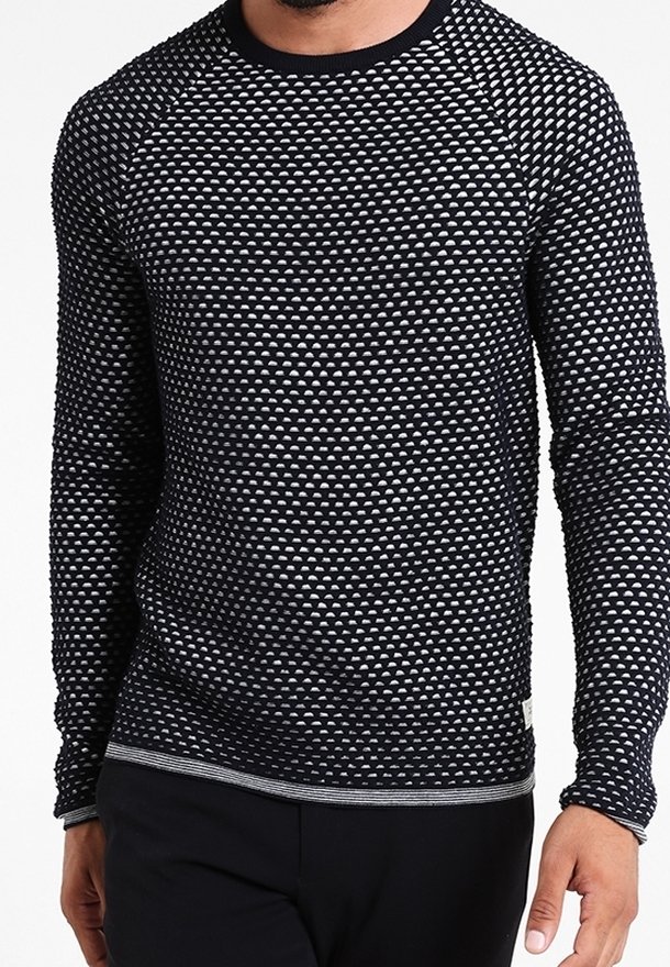 Pull à manches longues avec un motif triangulaire texturé noir et blanc, col rond, poignets et ourlet côtelés.