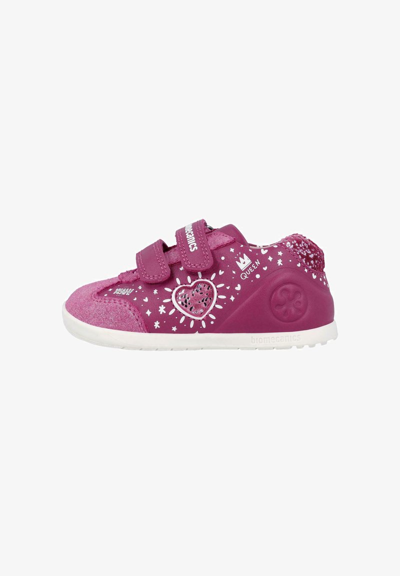 Zapatillas sintéticas rosas con acabado texturizado, que presentan patrones de estrellas blancas, un diseño de corazón y dos correas de cierre de gancho y lazo.