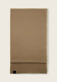 Bufanda beige hecha de un tejido suave, con bordes con flecos. Forma rectangular con una sección doblada en la parte inferior y un pequeño detalle de logotipo.