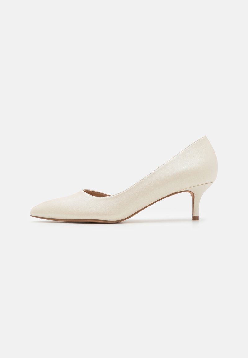 Beige lavhælede pump med spids tå og en glat, skinnende overflade. Har en subtil udskæring langs buen og en slank, opadgående hæl.