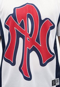 Αθλητική φανέλα από δίχτυ με μεγάλα στυλιζαρισμένα κόκκινα και ναυτικά μπλε επικαλυπτόμενα γράμματα "NR" σε λευκό φόντο.