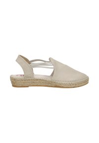 Beige espadrille-achtige schoen met een ronde neus, open zijkant en gevlochten jute zool. Glad oppervlak met dunne strapaccenten.