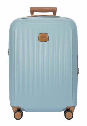 Valise rigide bleu clair avec poignée marron et roues, surface texturée et petit logo rectangulaire au centre avant.