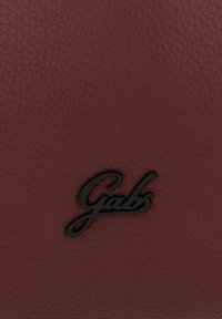 Billetera de cuero burdeos con un acabado texturizado y un logotipo en relieve negro, que añade contraste y detalle al diseño.