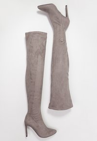 Botas de ante gris por encima de la rodilla, con punta puntiaguda y tacón alto de aguja, con cremallera lateral para cierre y textura suave.