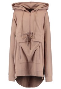 Sweat à capuche surdimensionné marron clair avec fermeture éclair frontale, cordons à la capuche et à la taille, poche kangourou avec deux fermetures éclair verticales, et ourlet incurvé prolongé.