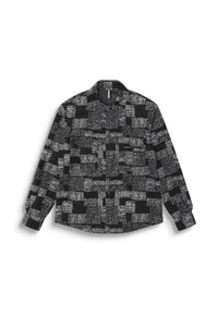 Langarmshirt van gestructureerde stof met een zwart-wit abstract blokpatroon, voorzien van een knoopsluiting en een klassieke kraag.