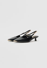 Juodai slingback aukštakulniai su smailiu padu, papildyti auksiniu akcentu ant galiuko ir grandinėlės detaile ant dirželio. Lygi odos tekstūra, vidutinio aukščio kulnas.