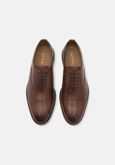 Chaussures de ville en cuir marron avec une finition lisse, un bout rond et un design à lacets. Présente des coutures contrastantes et un détail de bout cousu.