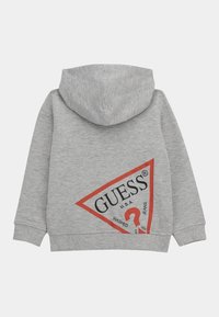 Sweat à capuche gris avec un grand logo en triangle rouge au dos, comportant le texte "GUESS U.S.A" et un point d'interrogation. Tissu doux et décontracté.