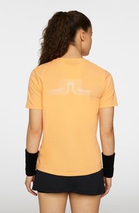 Kortärmad orange t-shirt med en vit geometrisk design på baksidan. Tillverkad av mjuk bomull och har en klassisk rund halsringning.