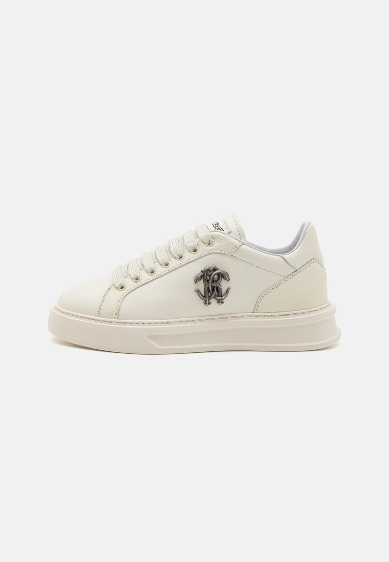 Vita lädersneakers med grå detaljer, med en logotyp på sidan, platta snörningar och en kontrasterande sula. Slät textur överlag.