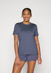 Marine atletisk skjorte, korte ermer, rund hals, lett stoff. Kombinert med matchende shorts. Har en diskret logo på ermet.