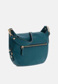 Torba na ramię z miękkiej skórki w kolorze morskim, o teksturowanym wykończeniu, z kieszenią na zamek błyskawiczny w kolorze złota, regulowanym paskiem i zaokrąglonym kształtem.