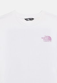 Λευκό T-shirt με στρογγυλή λαιμόκοψη και μικρό μωβ λογότυπο "The North Face Yosemite, CA" τυπωμένο στο αριστερό μέρος του στήθους, ετικεταρισμένο για κορίτσια μέγεθος 14/16.