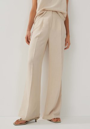 Beige, high-waisted wide-leg trousers made of smooth fabric with pintuck detailing and side pockets. Worn with a matching sleeveless top.