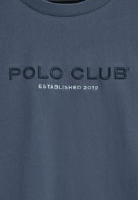 Mörkblå bomullströja med rund halsringning. Har broderad text "POLO CLUB" i mörk tråd och "ETABLERADE 2012" i ljusgrå.