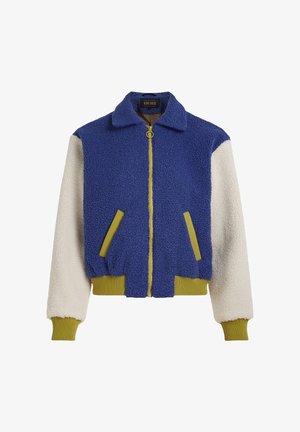 Chaqueta de bloques de color con cuerpo de forro polar azul, mangas en crema y detalles en verde. Cuenta con cierre frontal de cremallera, puños acanalados y bolsillos laterales.