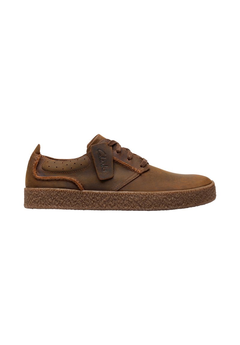 Braune Leder-Sneaker mit einer strukturierten braunen Sohle, ausgestattet mit dreieckigen Perforationen, Schnürverschluss und einem Markenetikett an der Seite.