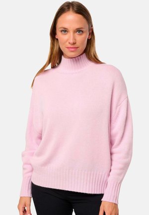 Pull à col roulé rose avec une coupe décontractée, ourlet et poignets côtelés, fabriqué en un tissu tricoté doux et texturé. La couleur est claire et uniforme.