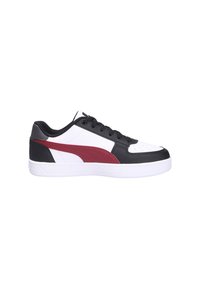 Zapatilla baja con base blanca, superposiciones negras, cordones negros y una franja roja en el lateral, vista desde el lado exterior.