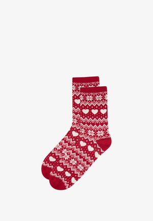 Red socks with white geometric patterns, including hearts and snowflakes, featuring ribbed cuffs and a soft texture.