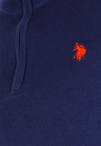 Marinefarbener Pullover mit strukturiertem Strick, ausgestattet mit einem halben Reißverschluss-Kragen und einem kleinen roten gestickten Logo eines Polo-Spielers auf der Brust.