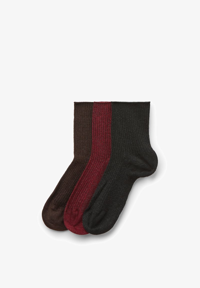 Trois chaussettes montantes côtelées en marron, bordeaux et noir, disposées côte à côte sur un fond blanc.