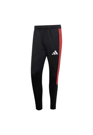 Pantalon de sport noir avec des bandes latérales rouges, confectionné dans un tissu lisse. Il présente une taille élastique et un logo Adidas blanc sur la partie inférieure de la jambe.