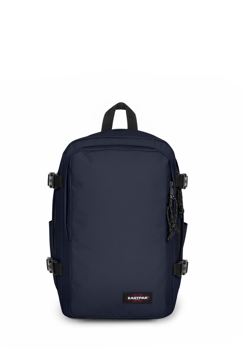 Zaino blu navy realizzato in tessuto resistente, con un design rettangolare, scomparti con zip, tasche laterali e una maniglia superiore per il trasporto.