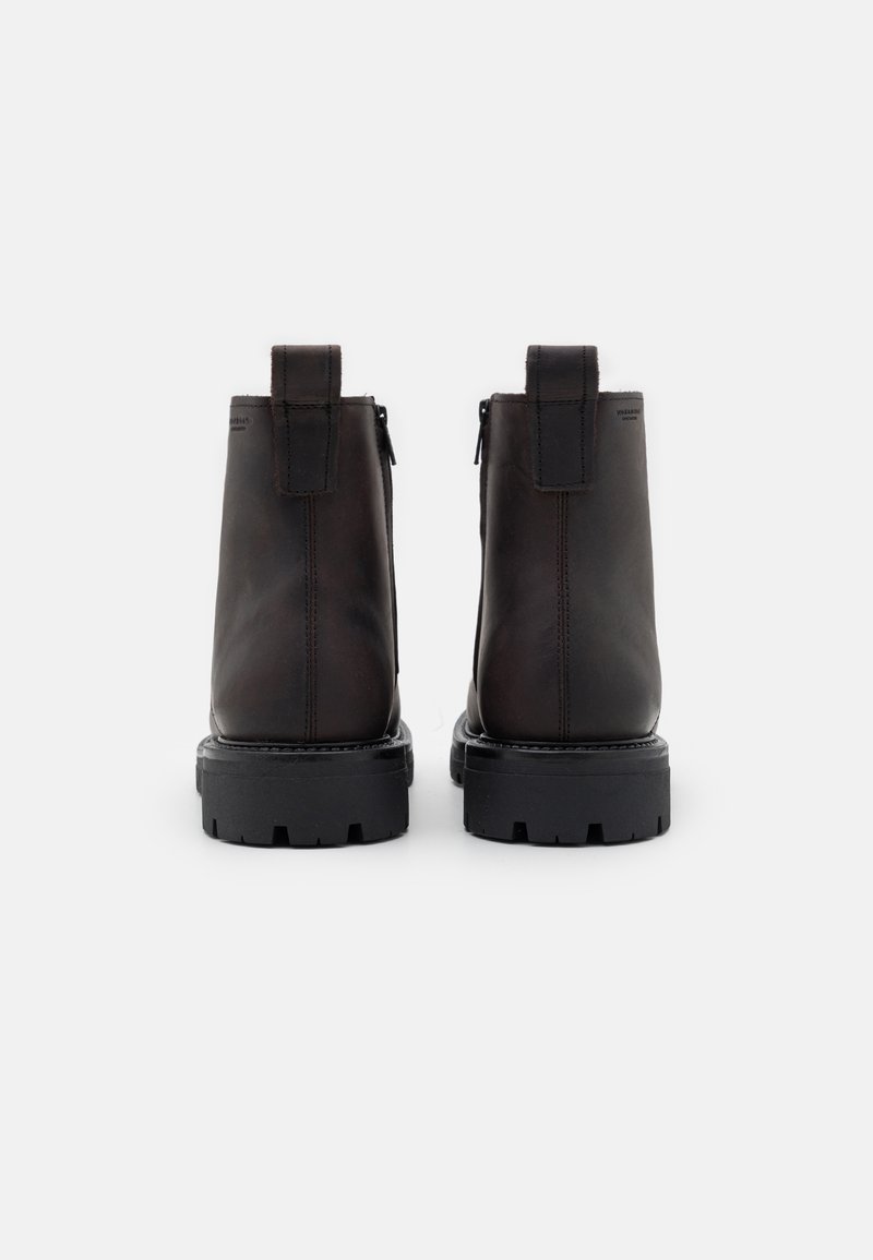 Brązowe skórzane botki za kostkę o eleganckim designie, z teksturowanym wykończeniem, bocznymi zamkami błyskawicznymi i solidnymi czarnymi gumowymi podeszwami.