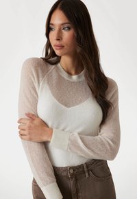 Merino wol sweater met doorschijnende lichtbeige mouwen, ronde halslijn en geribbelde manchetten. Het lichaam is effen wit en heeft een subtiele hartvormige ontwerp.