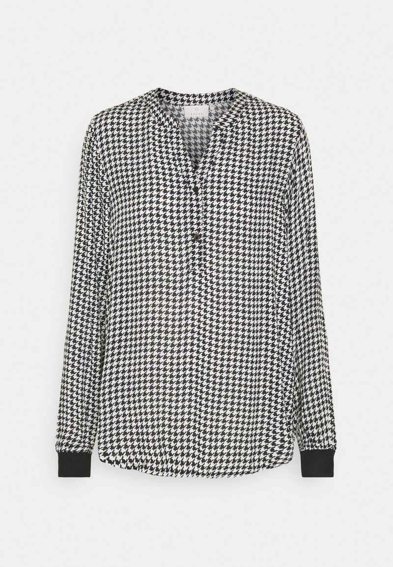 Blouse à manches longues pied-de-poule noir et blanc avec poignets noirs et patte de boutonnage partielle à l'avant.