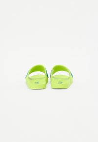 Sandali verde neon con cinturino blu, dotati di suola testurizzata e design aperto sul retro, adatti per un abbigliamento casual.