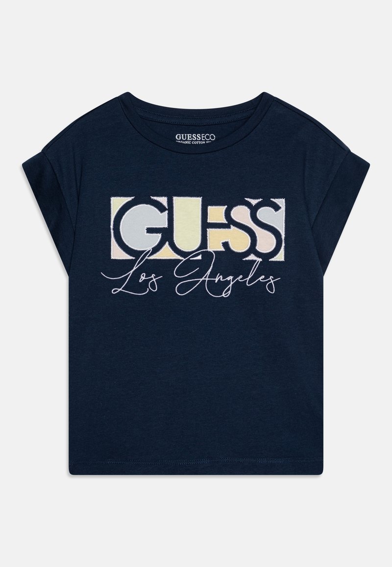 Navy blue short-sleeve t-shirt made of organic cotton featuring a large multi-color "GUESS" logo and cursive "Los Angeles" text at the center.