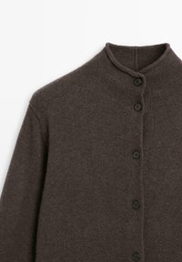 Cardigan en tricot marron foncé avec col montant et cinq boutons noirs sur le devant, présenté à plat sur un fond blanc.
