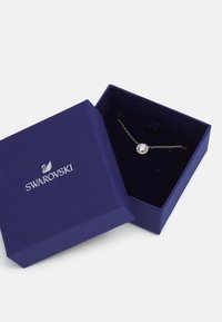 Scatola regalo Swarovski di colore blu scuro che mostra un bracciale in argento con un centro in cristallo rotondo circondato da cristalli più piccoli.