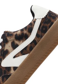 Sneaker con stampa leopardata e dettagli bianchi, upper in suede, superficie testurizzata e suola in gomma marrone. Presenta cuciture in contrasto.